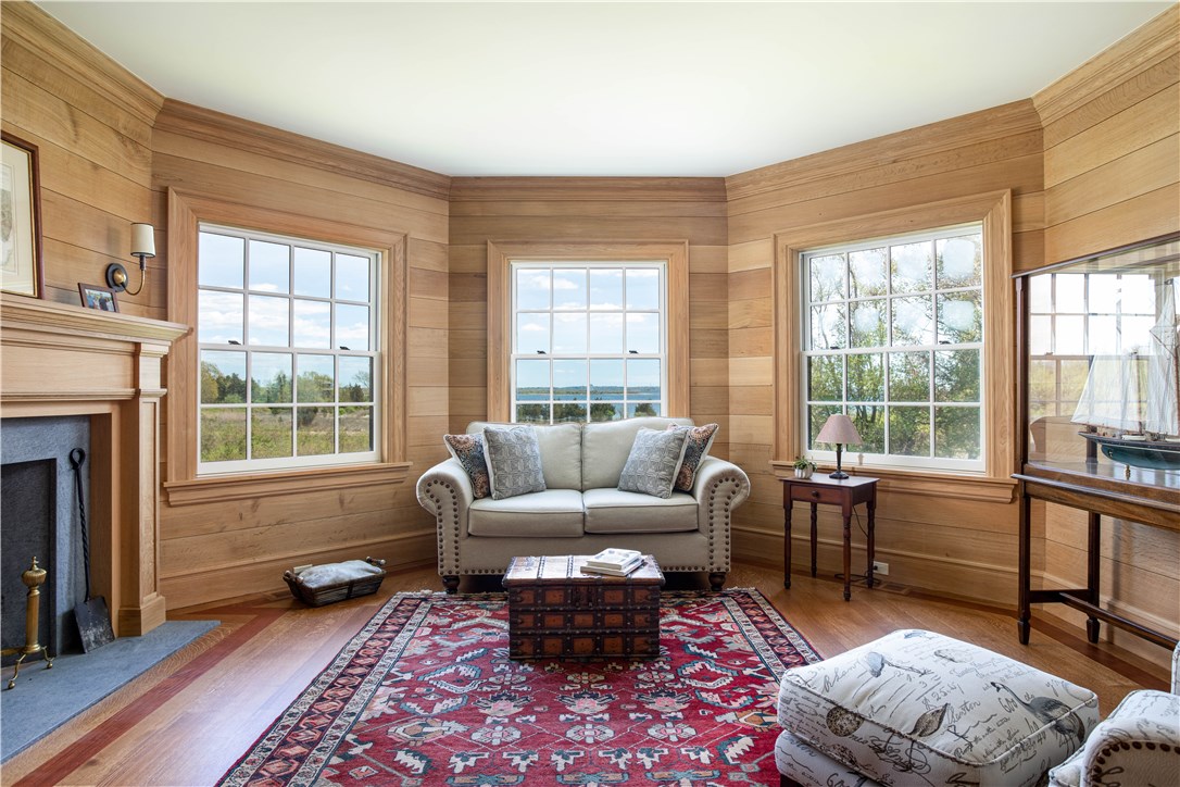 415 Poppasquash Road Bristol, RI 02809 - Photo 22 of 50 Exquisite den with 4" oak floors, soapstone lined fireplace, and custom wall paneling in a unique octagon shape that offers more water views.