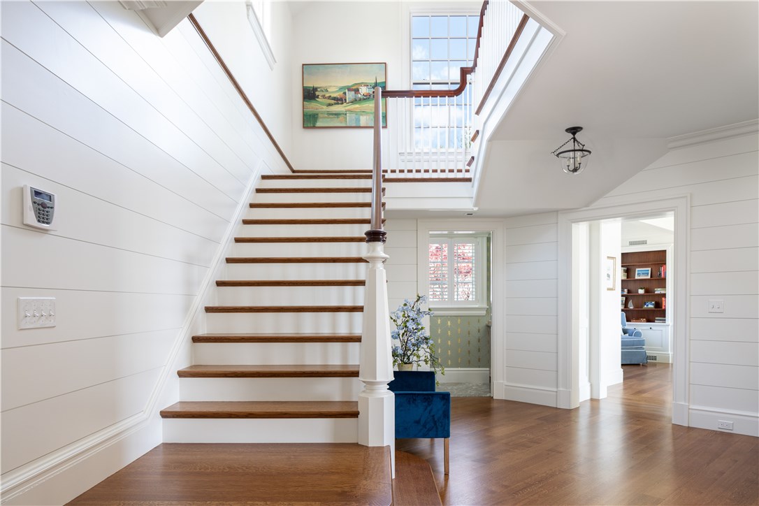 415 Poppasquash Road Bristol, RI 02809 - Photo 8 of 50 Grand staircase which leads to an expansive landing above with a half bath and living-room off in the distance on the main level.