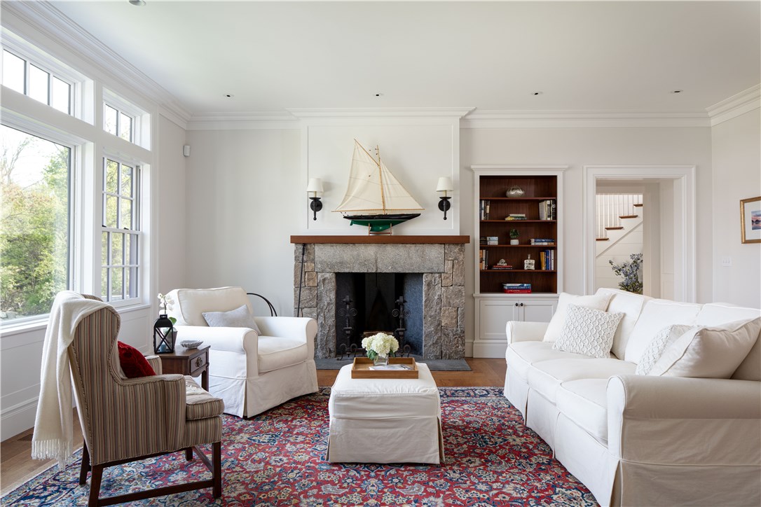 415 Poppasquash Road Bristol, RI 02809 - Photo 10 of 50 Living room featuring beautiful millwork and a spectacular soapstone lined fireplace with a mantle made of mahogany wood which was thoughtfully saved from the original structure that was once located on 415 Poppasquash.