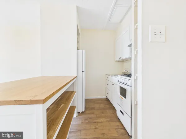 a view of a kitchen with white cabinets and white appliances