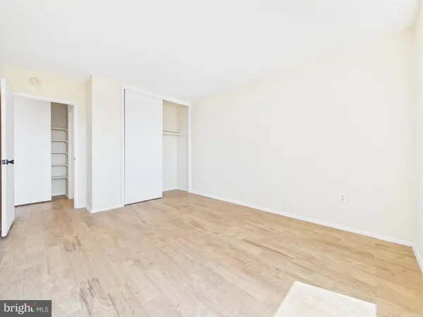 a view of an empty room with closet and a window