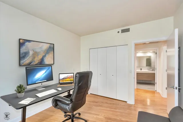 a view of a workspace with furniture and a window