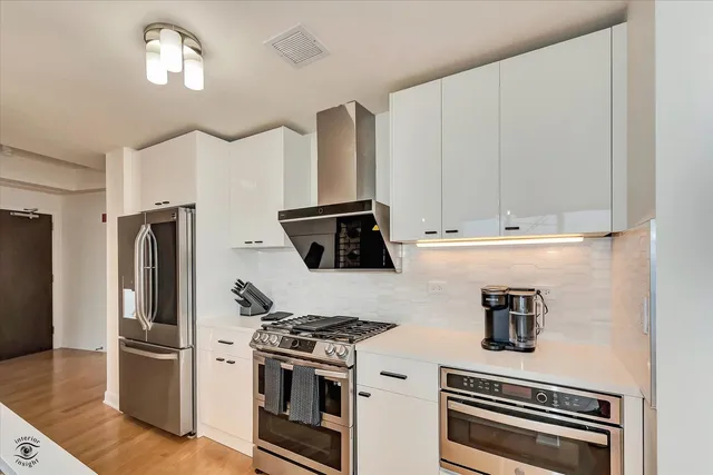 a kitchen with stainless steel appliances granite countertop a stove and a refrigerator