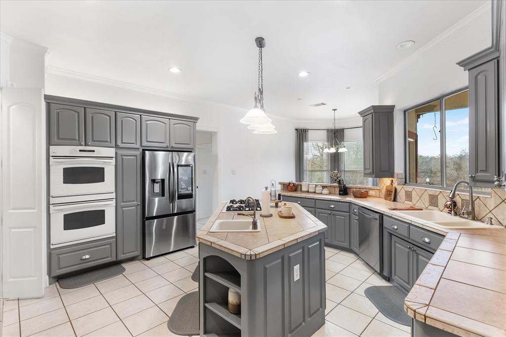 117 Redtail Court Weatherford, TX 76088 - Photo 15 of 39 a kitchen with a sink stove and refrigerator