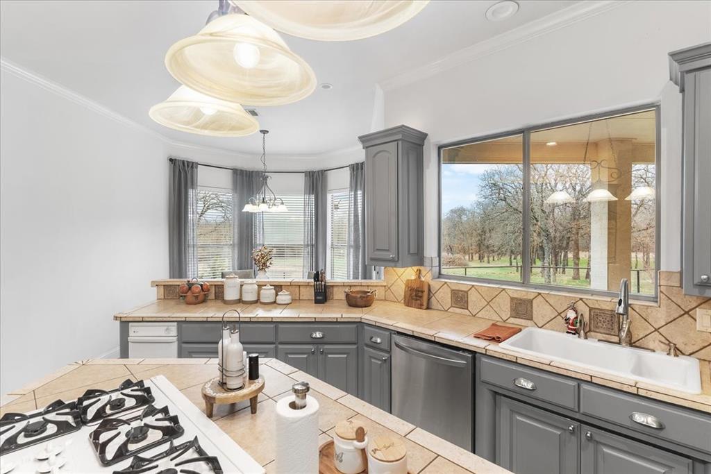 117 Redtail Court Weatherford, TX 76088 - Photo 17 of 39 a kitchen with a large window and cabinets