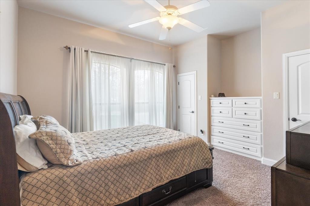 117 Redtail Court Weatherford, TX 76088 - Photo 26 of 39 a bedroom with a bed and a chandelier
