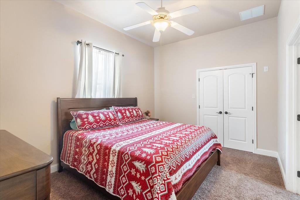 117 Redtail Court Weatherford, TX 76088 - Photo 28 of 39 a bedroom with a large bed and a chandelier