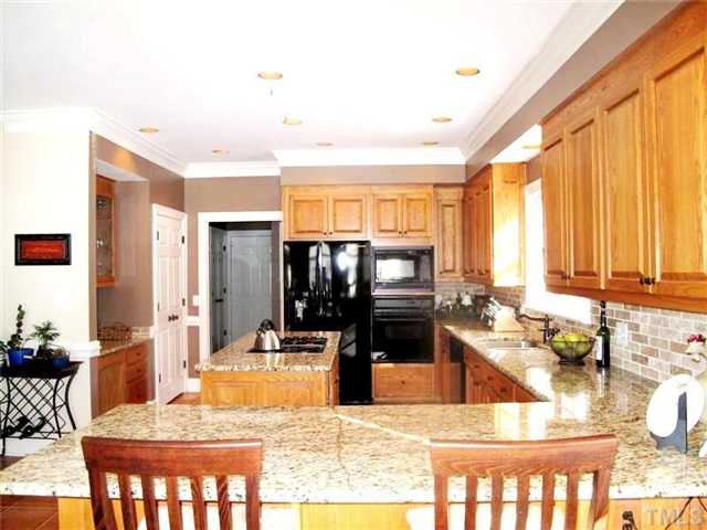 5801 Orchid Valley Road Raleigh, NC 27613 - Photo 8 of 25 a kitchen with sink refrigerator and dining table