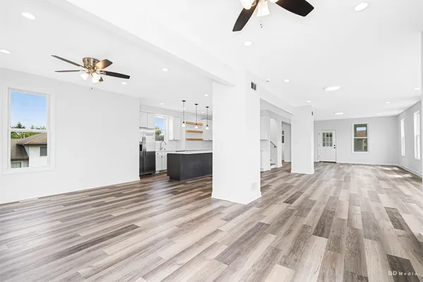 a view of empty room with wooden floor and ceiling fan