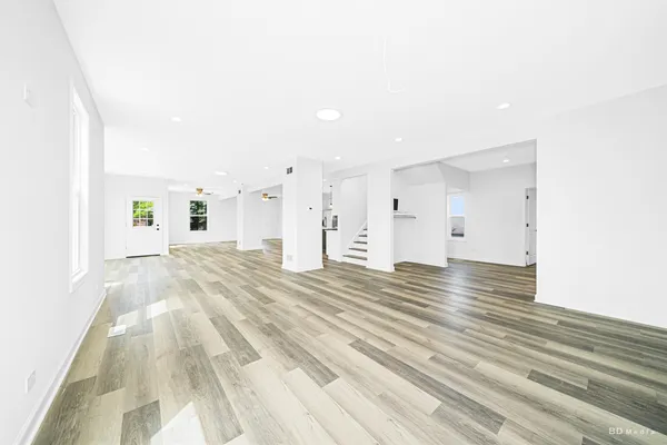 a view of a bedroom with wooden floor and windows