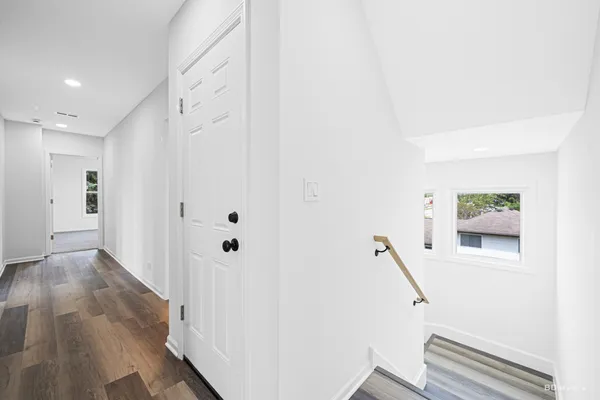 a view of a hallway with wooden floor and entryway
