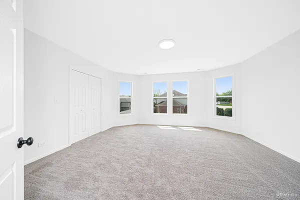 an empty room with a windows and closet
