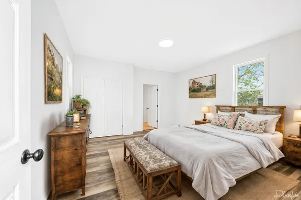 a bedroom with a bed and wooden floor