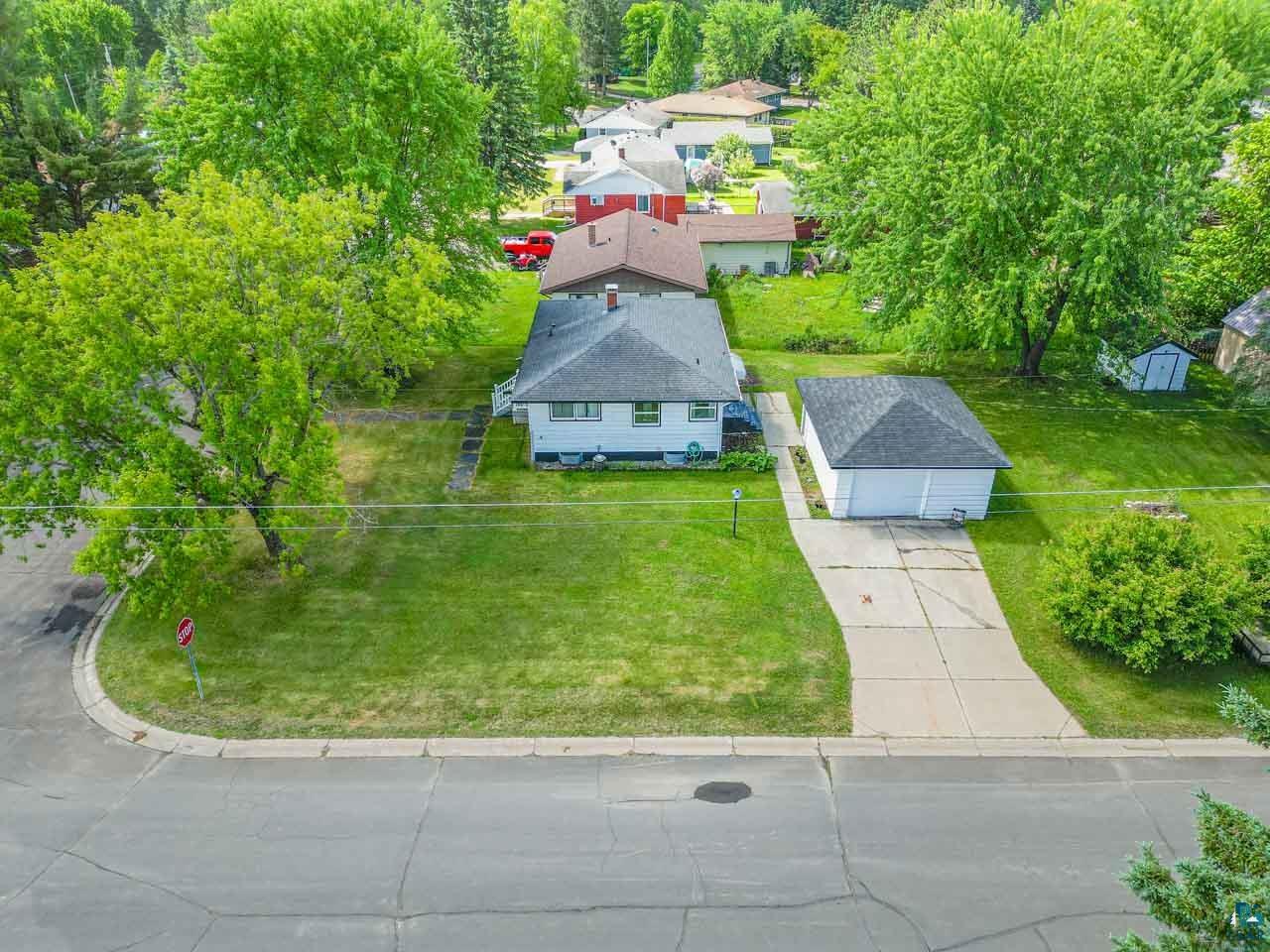 301 2nd Street North Biwabik, MN 55708 - Photo 40 of 43 Corner lot property featuring a detached two-car garage, mature trees, a concrete driveway, and a residential street frontage