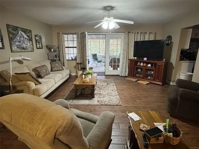 a living room with furniture a large window and a flat screen tv