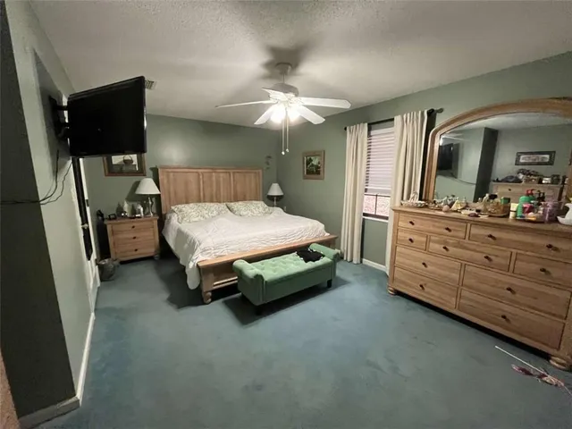 a bedroom with a bed and a flat tv screen on dresser