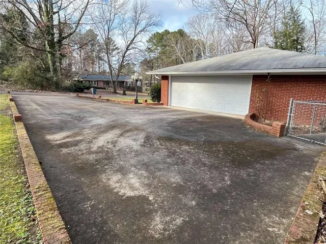 a view of a house with backyard and trees