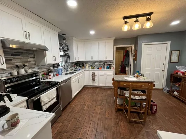 a kitchen with a table chairs stove and cabinets