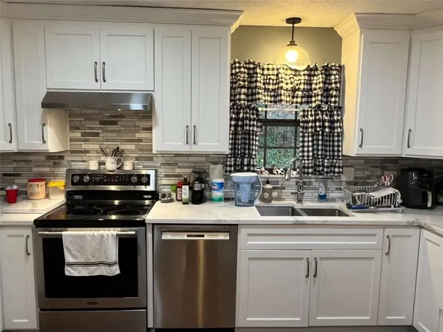 a kitchen with a sink stove and cabinets