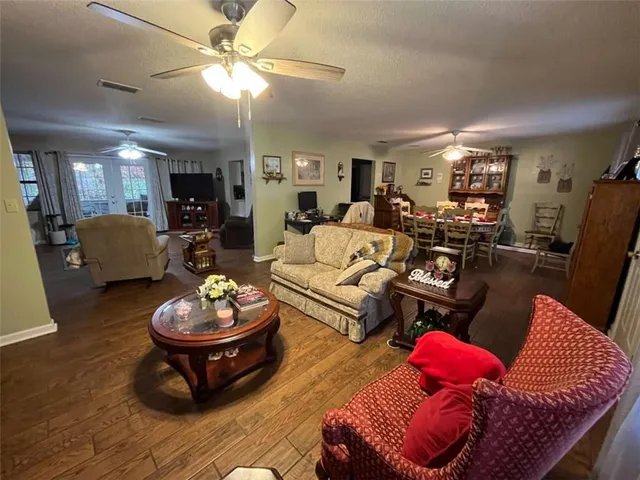a living room with furniture and a wooden floor
