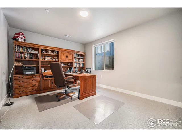 a view of a workspace with furniture and a bookshelf