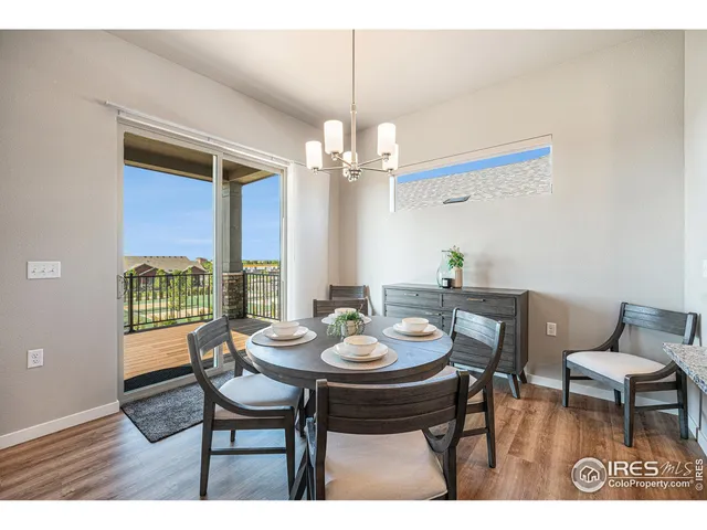 a dining room with furniture a chandelier and wooden floor