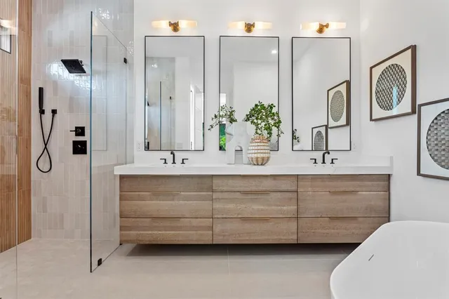 a bathroom with a double vanity sink mirror and shower