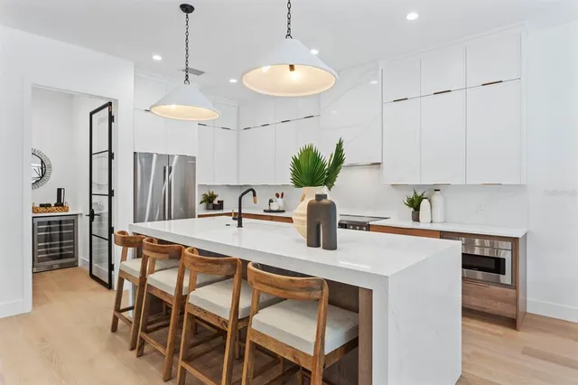 a kitchen with stainless steel appliances granite countertop a kitchen island a stove a table and chairs in it