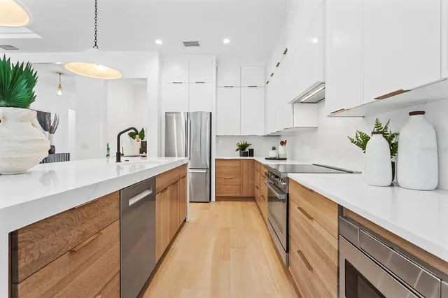 a kitchen with kitchen island granite countertop a sink a counter top space stainless steel appliances and cabinets