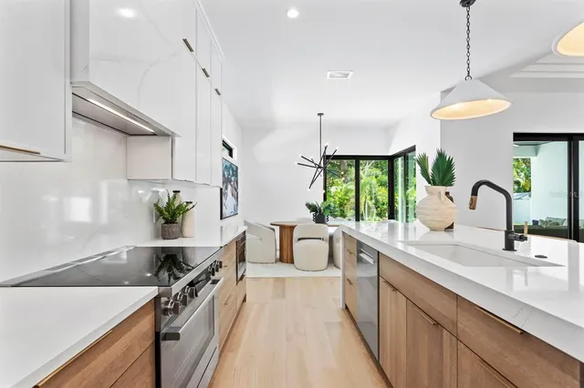 a large kitchen with kitchen island a large counter space a sink appliances and a counter top space