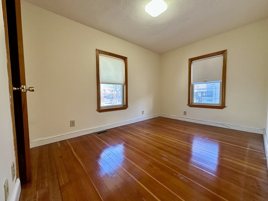 5 Rifle Court, Unit 5 Watertown, MA 02472 - Photo 10 of 14 an empty room with wooden floor and windows