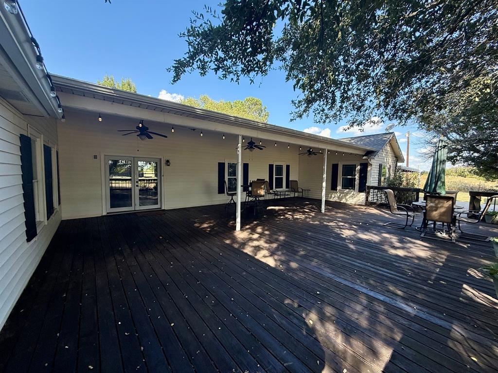 3420 Springfield Road Springtown, TX 76082 - Photo 9 of 38 a view of a patio with table and chairs with wooden floor and fence