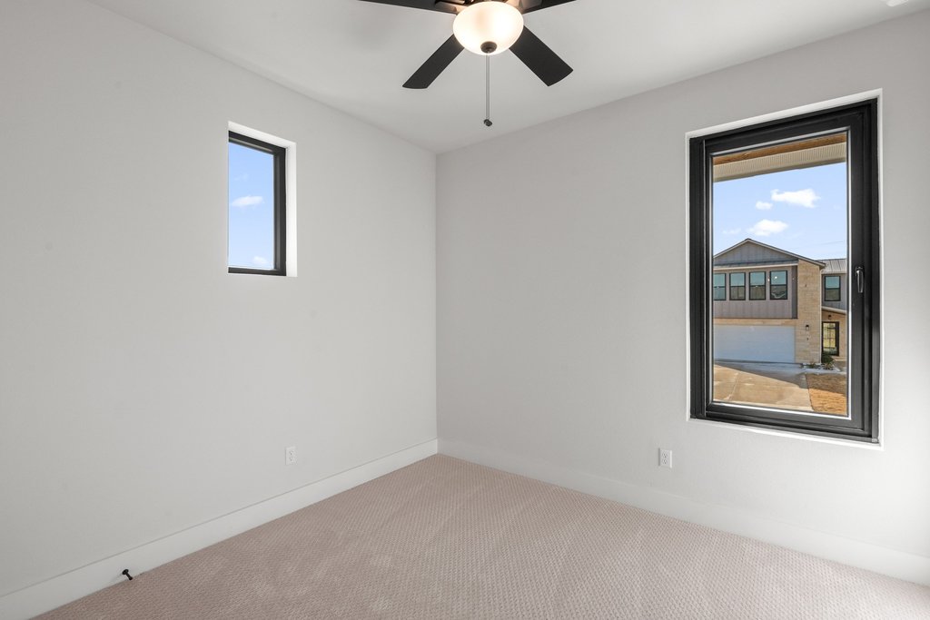 711 Paleface Ranch Road, Unit 9 Spicewood, TX 78669 - Photo 18 of 30 Spare room with carpet floors and ceiling fan