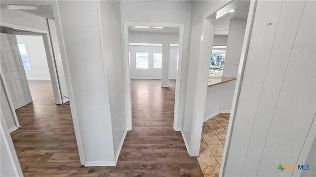 a view of a hallway with wooden floor and staircase
