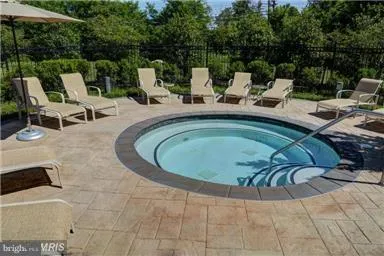 a view of backyard with swimming pool and seating space