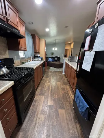 a large kitchen with a stove wooden cabinets and a sink