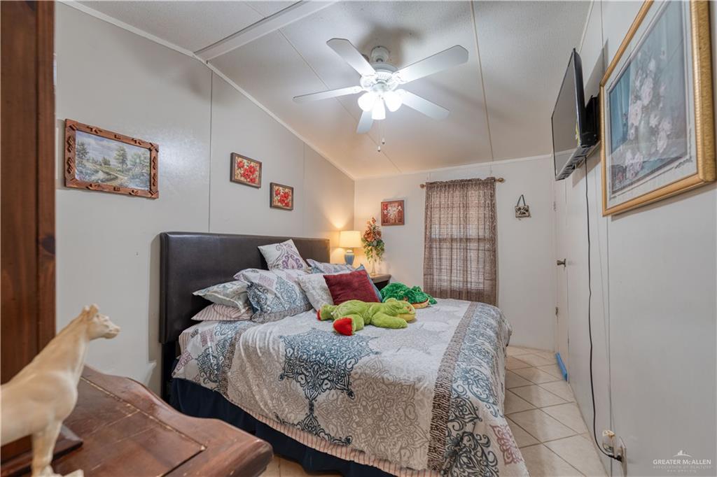 220 Delmita Road Delmita, TX 78536 - Photo 23 of 33 a bedroom with a bed and a chandelier