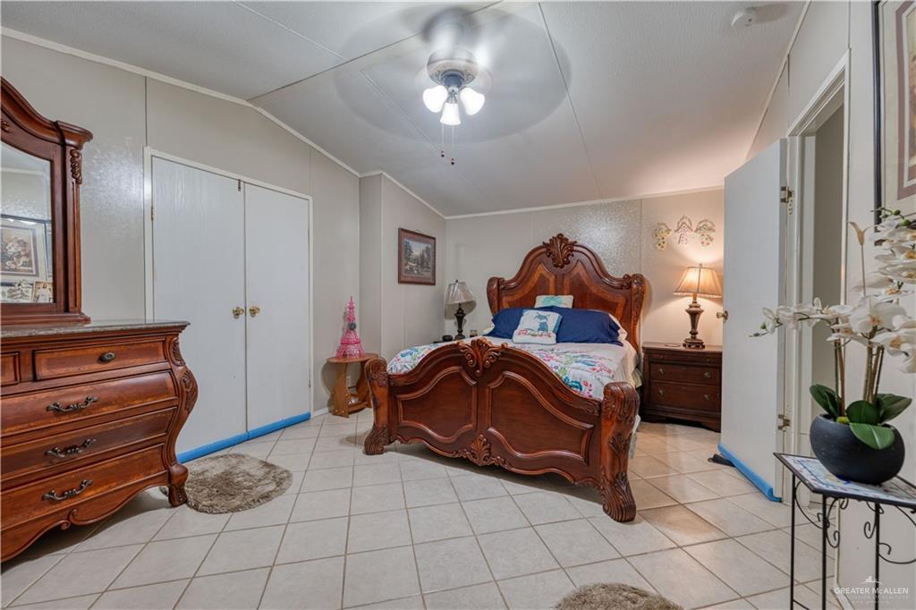 220 Delmita Road Delmita, TX 78536 - Photo 28 of 33 a bedroom with a bed and a chandelier
