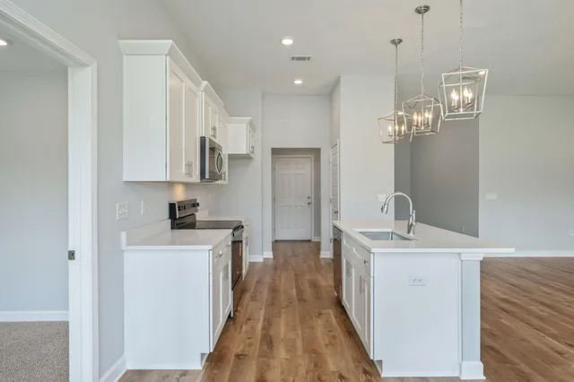 a kitchen with white cabinets appliances and sink
