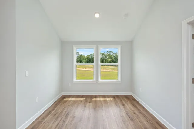an empty room with a window and wooden floor