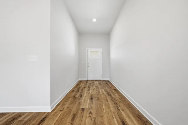 a view of a hallway with wooden floor