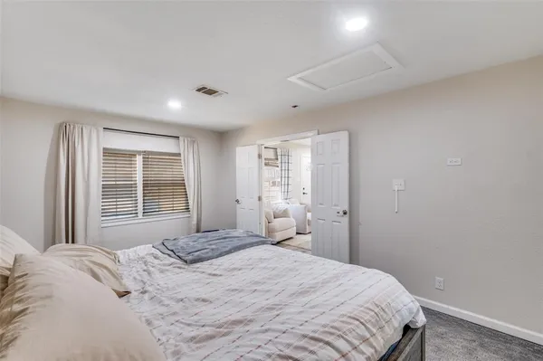 a bedroom with a large bed and a window