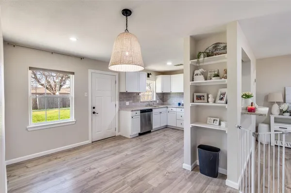 a kitchen with stainless steel appliances a stove a window and wooden floor