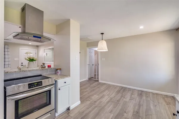 a kitchen with a stove and a wooden floor