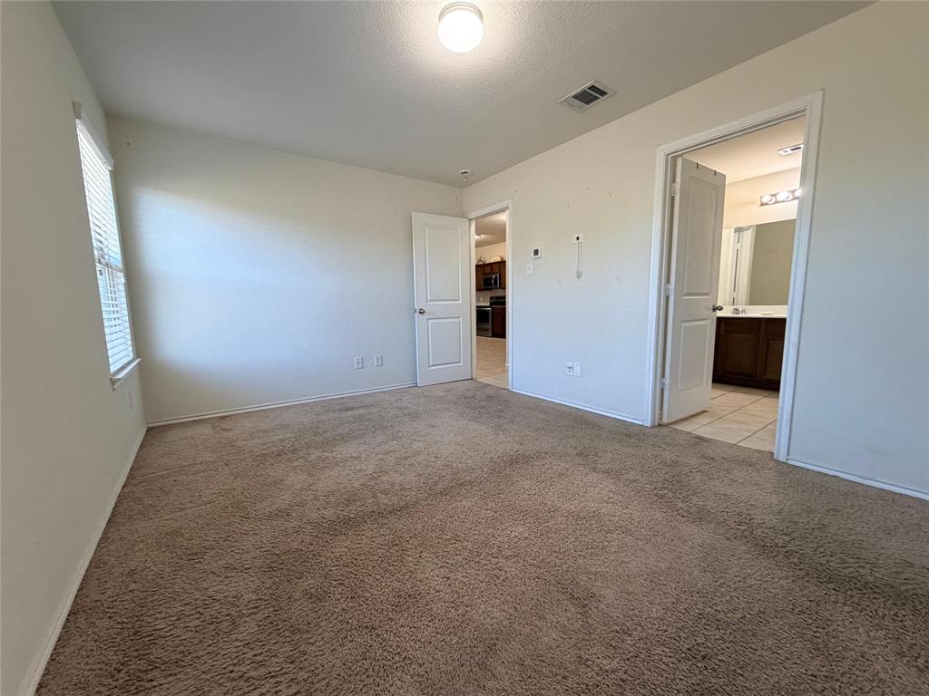 2203 Vance Drive Forney, TX 75126 - Photo 11 of 23 Unfurnished bedroom featuring light carpet and a textured ceiling
