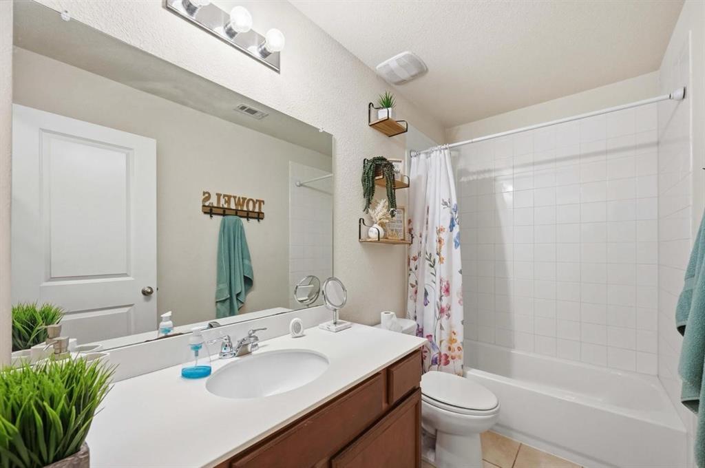 2203 Vance Drive Forney, TX 75126 - Photo 17 of 23 Bathroom featuring shower / bath combo with shower curtain, vanity, and light tile patterned flooring