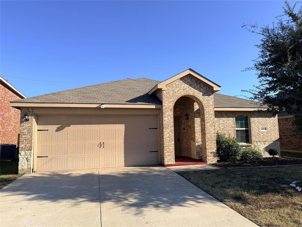 2203 Vance Drive Forney, TX 75126 - Photo 2 of 23 View of front facade featuring brick siding, concrete driveway, roof with shingles, and a garage