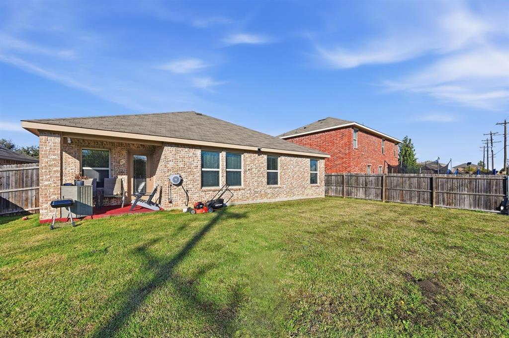 2203 Vance Drive Forney, TX 75126 - Photo 21 of 23 Rear view of house with a fenced backyard, a patio area, brick siding, and a shingled roof