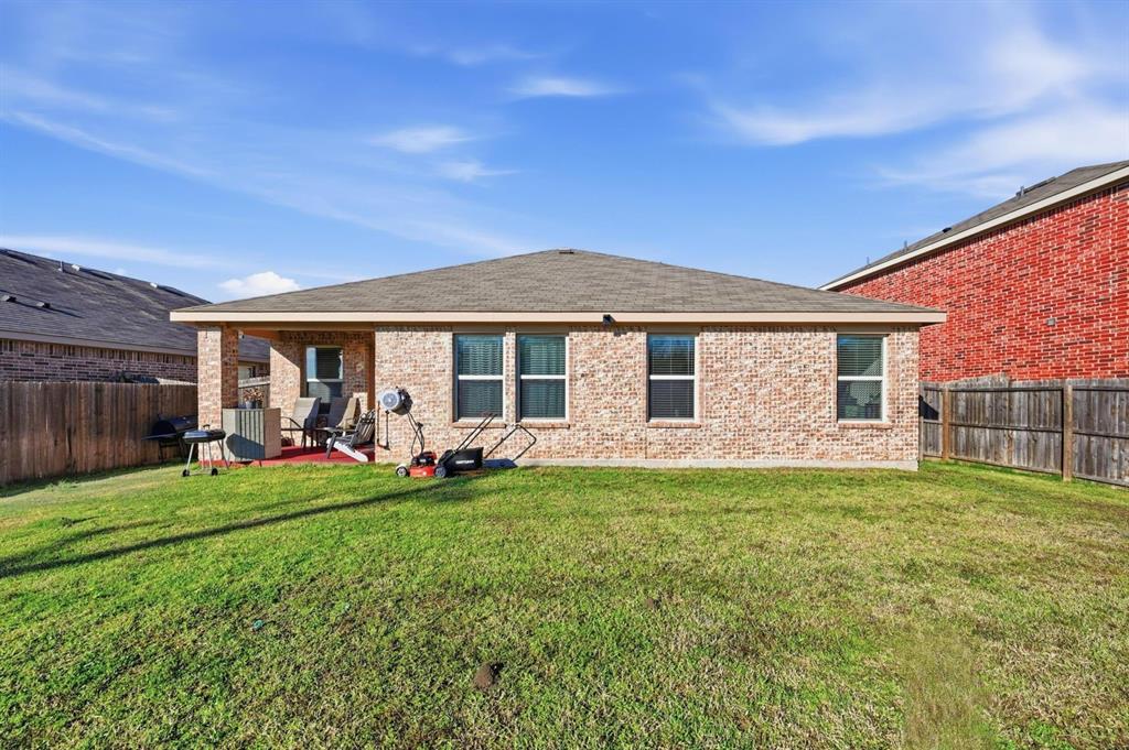 2203 Vance Drive Forney, TX 75126 - Photo 22 of 23 Back of property featuring a fenced backyard, brick siding, a shingled roof, and a patio