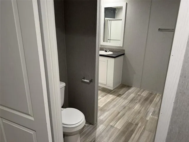 a bathroom with a granite countertop toilet and a sink